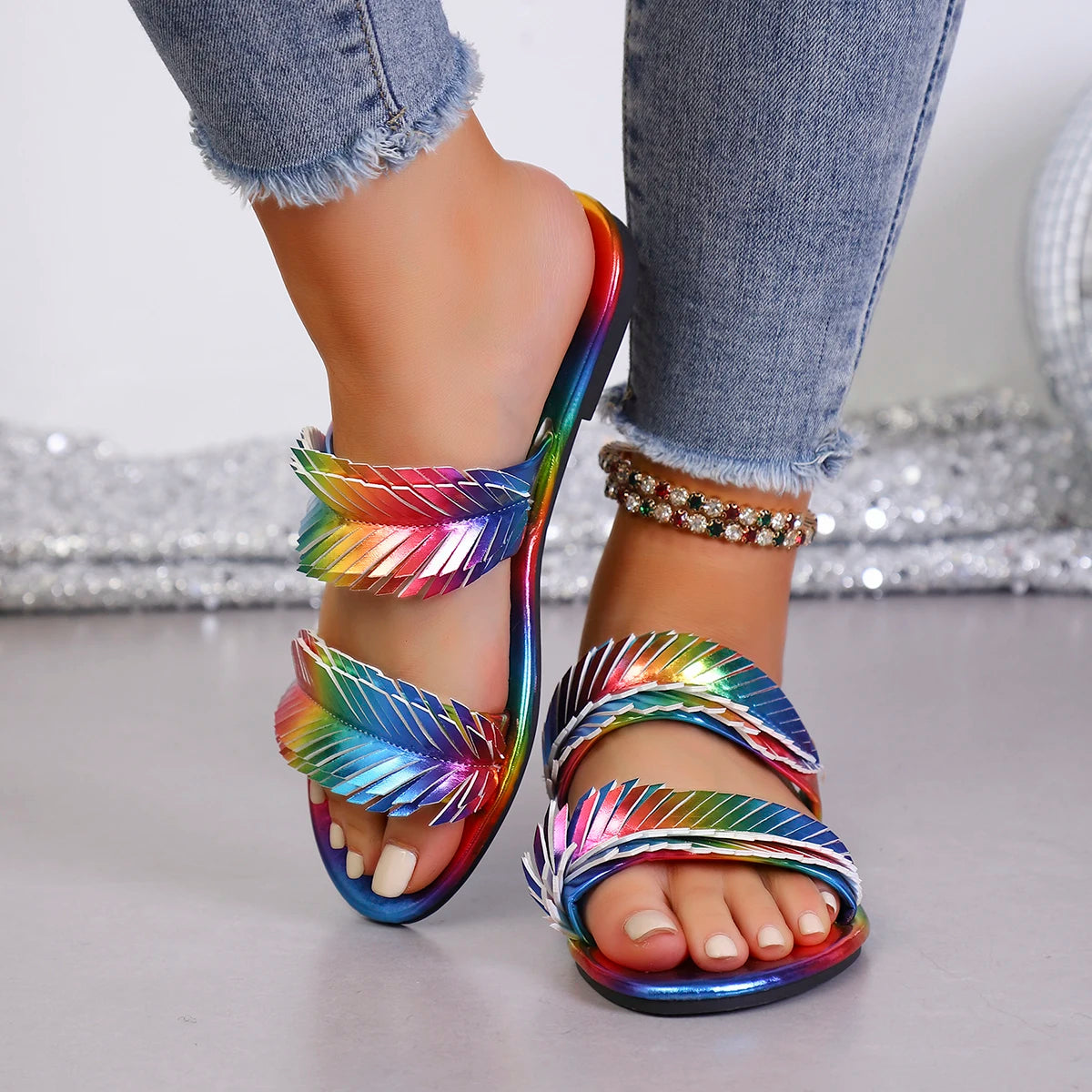 Femme portant des sandales à brides feuilles multicolores avec un jeans bleu – look estival joyeux